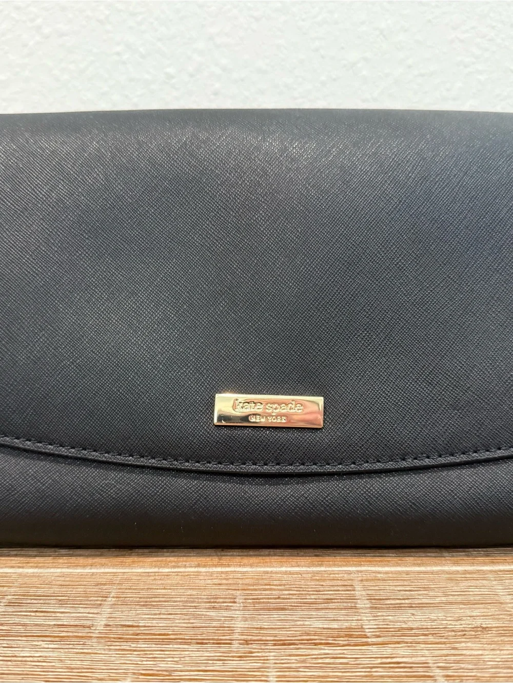 Kate Spade black leather clutch with gold logo plaque